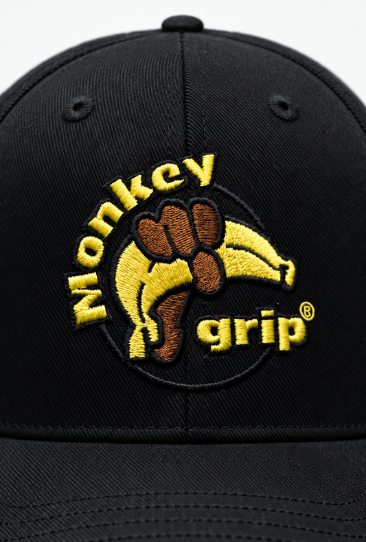 Närbild på broderad Monkey Grip-logga på kepsen
